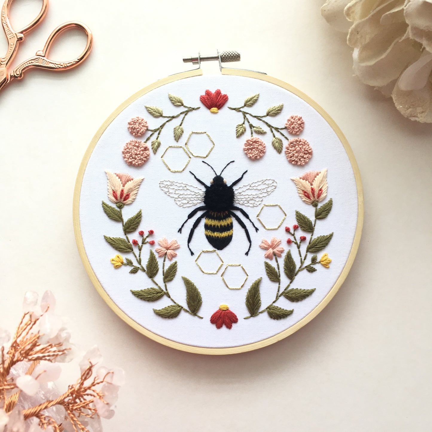 embroidery design featuring a honeybee surrounded by a floral motif